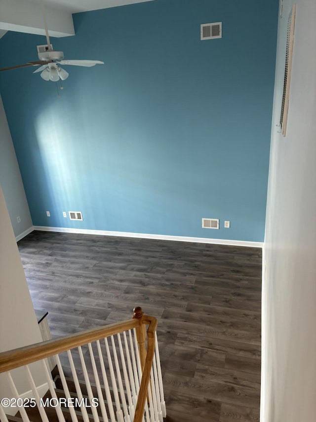 empty room with dark wood-type flooring and ceiling fan