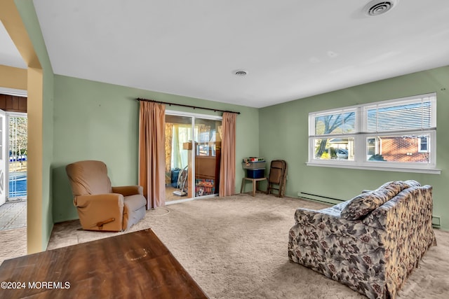 sitting room with a healthy amount of sunlight, light carpet, and a baseboard radiator