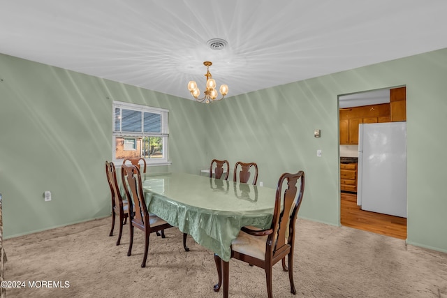 carpeted dining room featuring an inviting chandelier