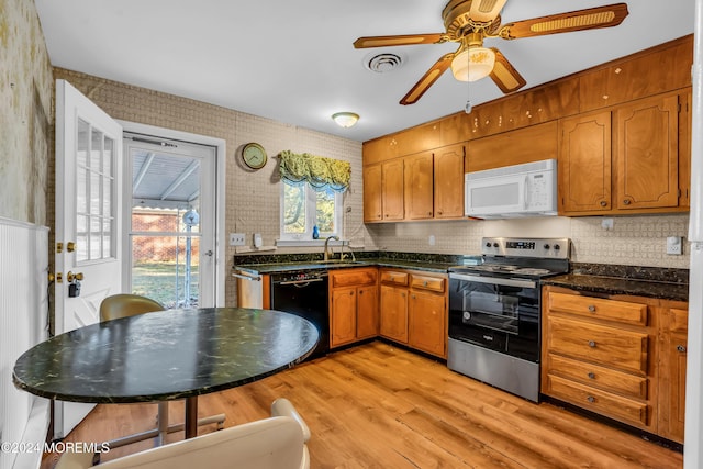 kitchen featuring ceiling fan, sink, stainless steel appliances, backsplash, and light wood-type flooring