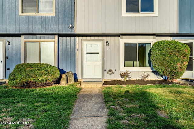 entrance to property featuring a yard