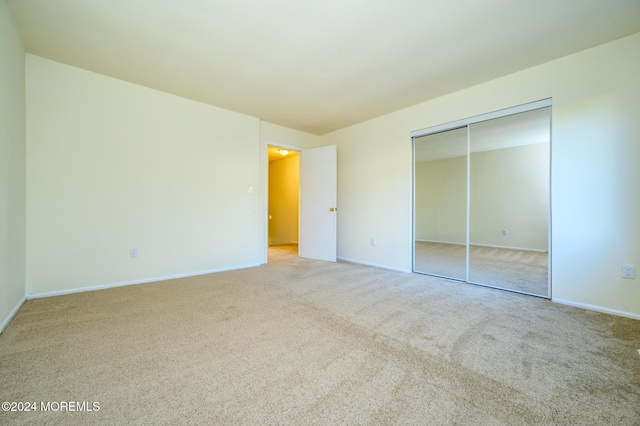 unfurnished bedroom featuring carpet floors and a closet