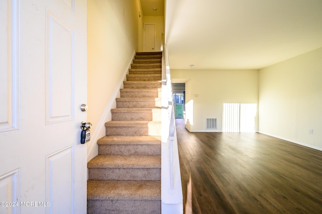 staircase featuring wood-type flooring