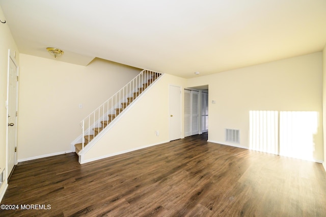 unfurnished living room with dark hardwood / wood-style flooring