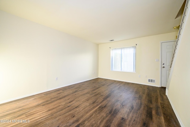 empty room with dark hardwood / wood-style flooring