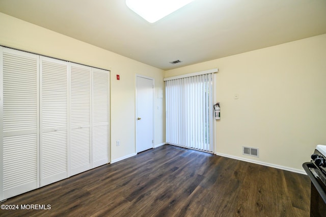 unfurnished bedroom featuring a closet and dark hardwood / wood-style floors