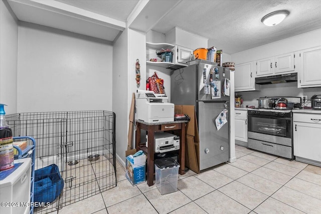 kitchen featuring white cabinets, light tile patterned floors, a textured ceiling, and appliances with stainless steel finishes