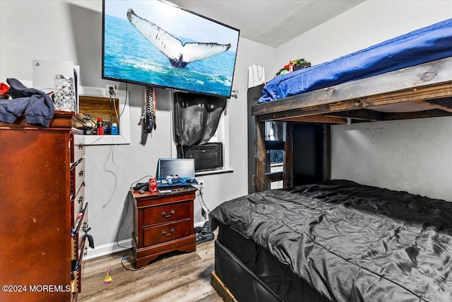 bedroom with cooling unit and hardwood / wood-style flooring