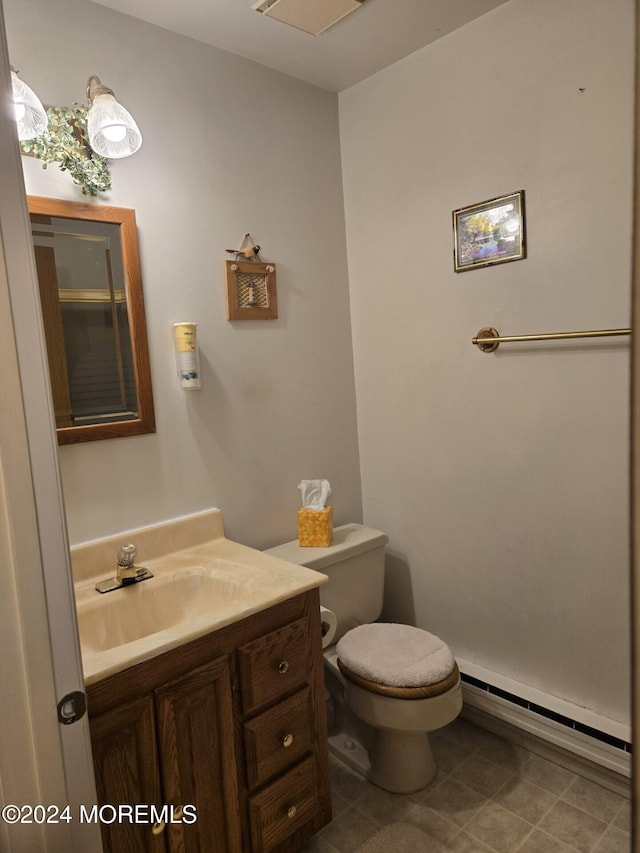 bathroom with vanity, toilet, and a baseboard heating unit