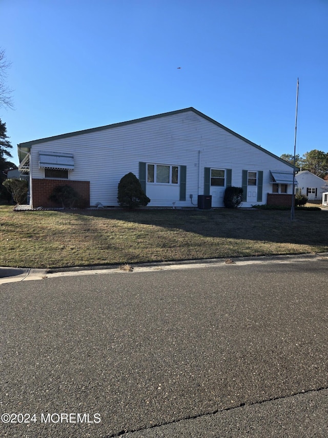 exterior space with cooling unit and a front yard