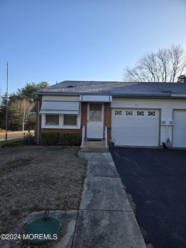 single story home with a front yard and a garage