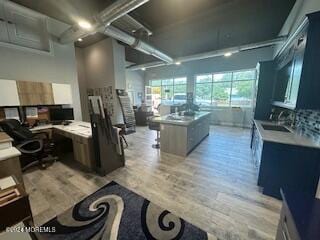 kitchen featuring light wood-type flooring, a kitchen island, and sink