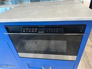 room details featuring oven and blue cabinetry