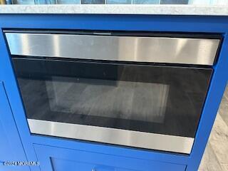 interior details featuring blue cabinetry and stainless steel oven