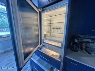 details featuring decorative backsplash and refrigerator