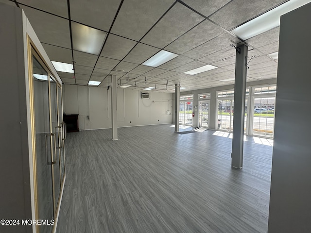 interior space featuring plenty of natural light, a drop ceiling, and hardwood / wood-style flooring