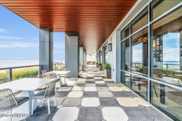 balcony with a water view and a view of the beach