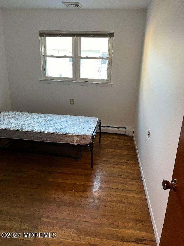 bedroom with dark hardwood / wood-style flooring