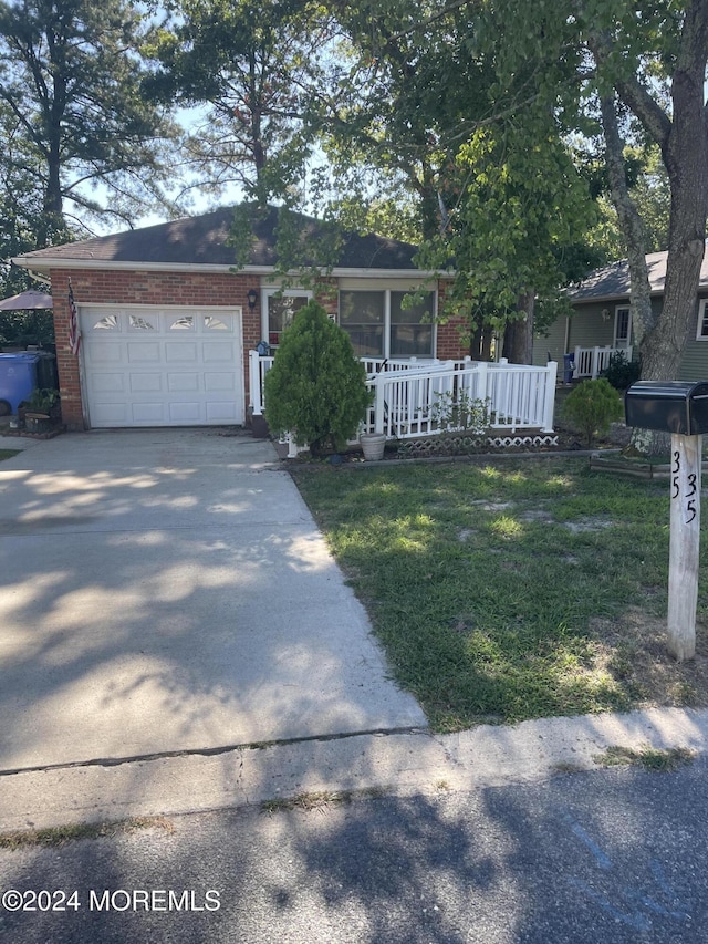 ranch-style house with an attached garage, driveway, a front yard, and brick siding