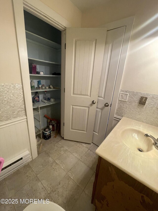 bathroom featuring a wainscoted wall and vanity