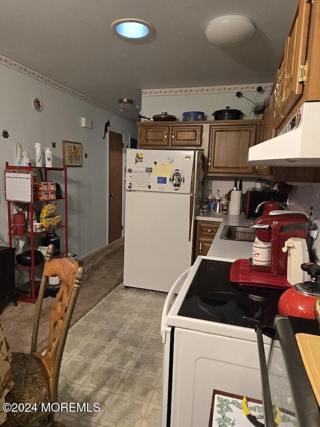 kitchen with light carpet, sink, and white appliances