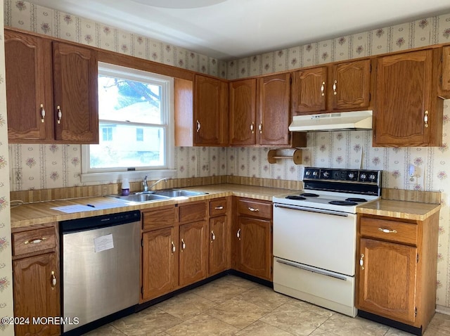 kitchen featuring sink, tile countertops, stainless steel dishwasher, and electric stove