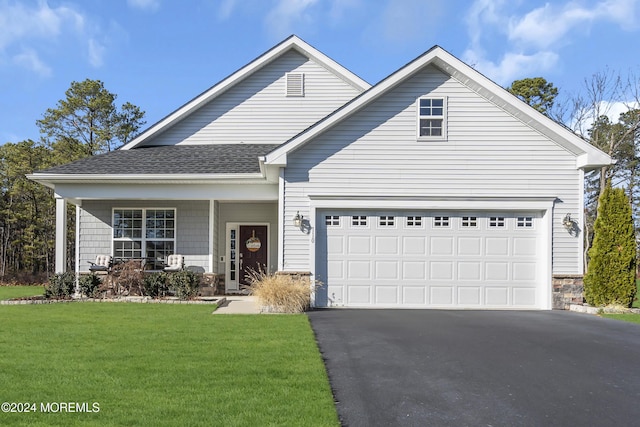 view of front property with a porch, a garage, and a front yard