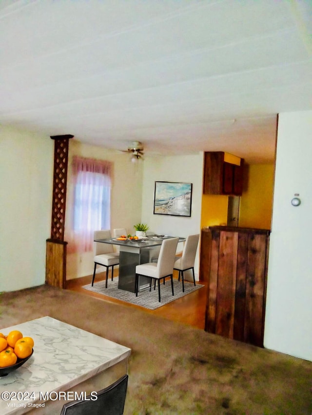 carpeted dining space with ceiling fan