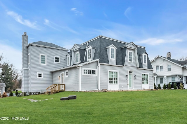 view of front of house with a shingled roof and a front yard