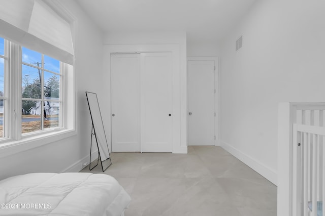 bedroom with a closet, visible vents, and baseboards