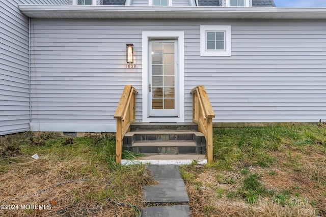 entrance to property with roof with shingles and mansard roof