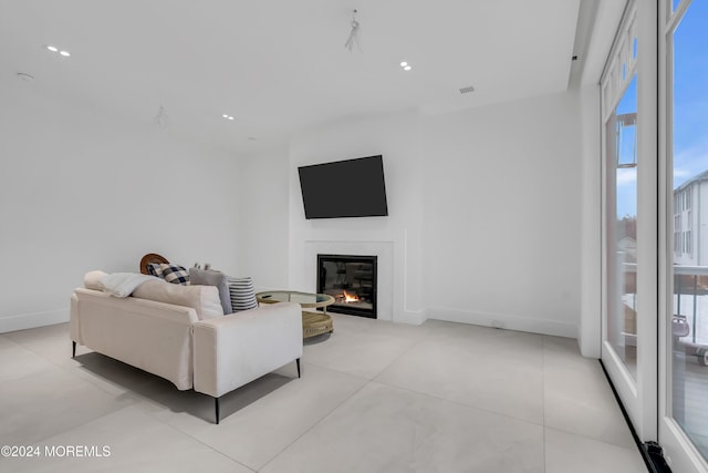 living room with recessed lighting, visible vents, baseboards, and a glass covered fireplace