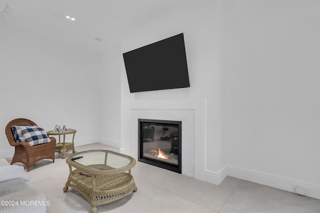 living area with a glass covered fireplace and baseboards