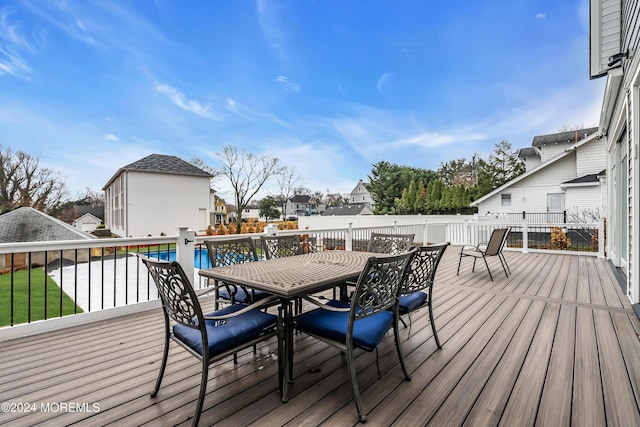 deck featuring a fenced in pool and outdoor dining space