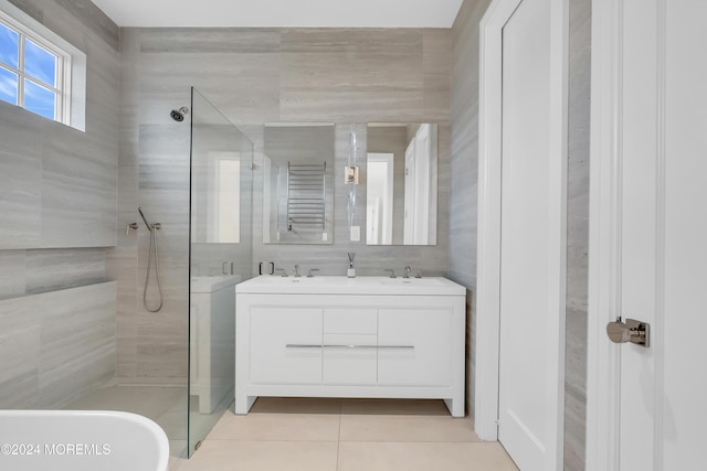 full bath with a sink, double vanity, tile patterned flooring, and walk in shower