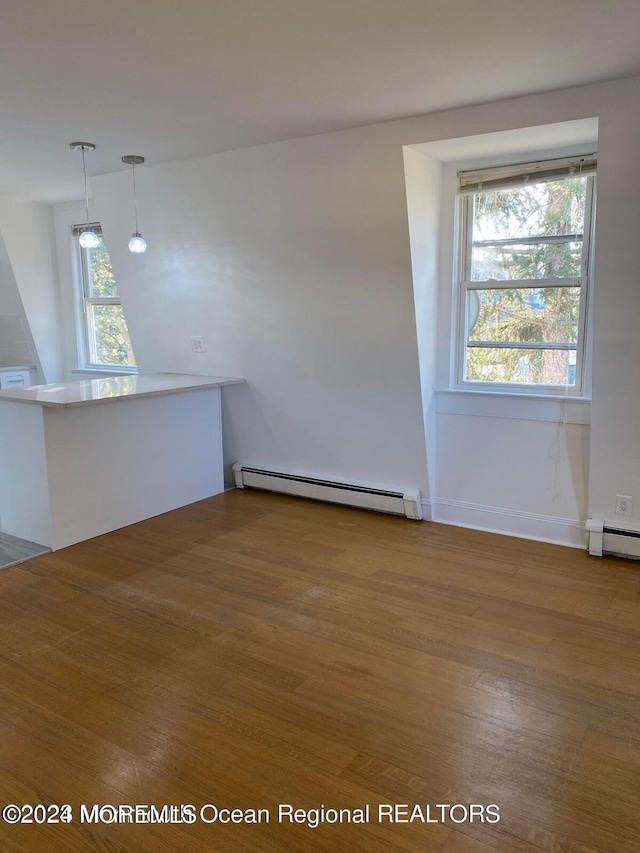 interior space featuring baseboard heating and wood finished floors