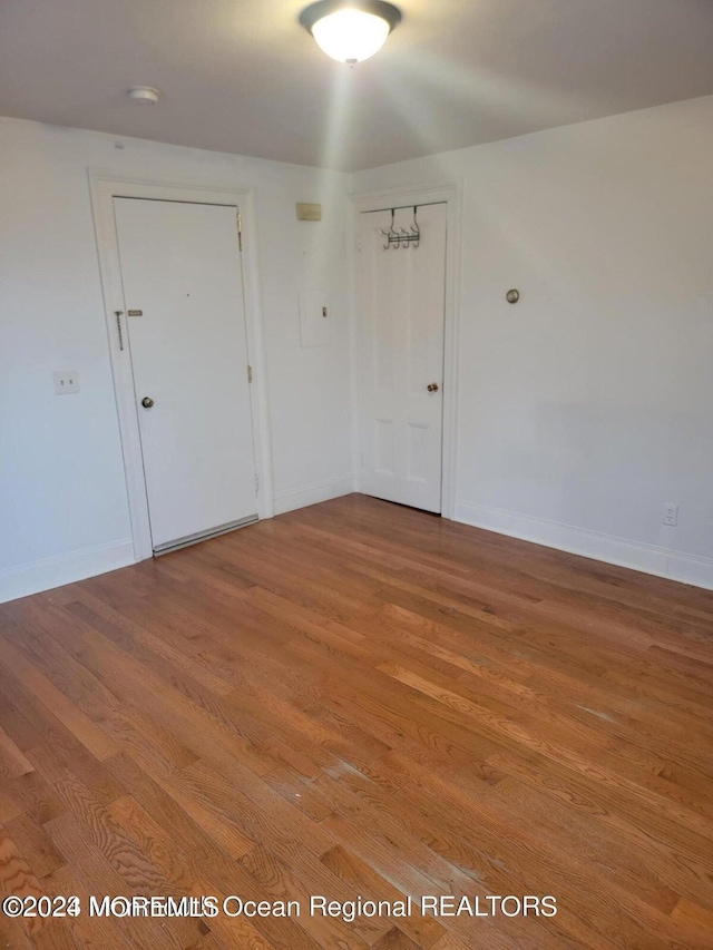 spare room featuring baseboards and wood finished floors