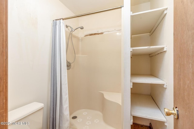 bathroom with a shower with curtain and toilet