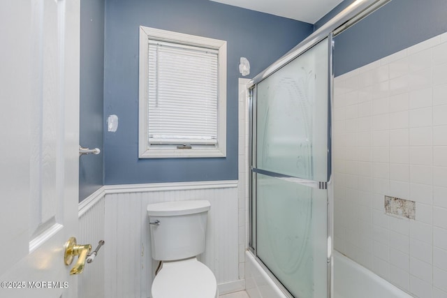 bathroom featuring toilet and enclosed tub / shower combo