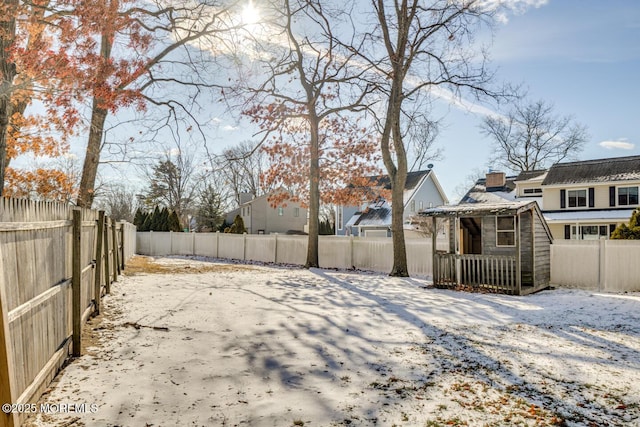 yard layered in snow with an outbuilding