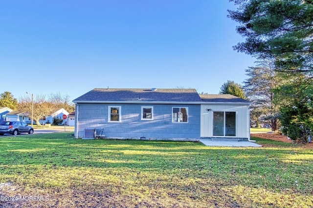 back of property with a yard and central air condition unit