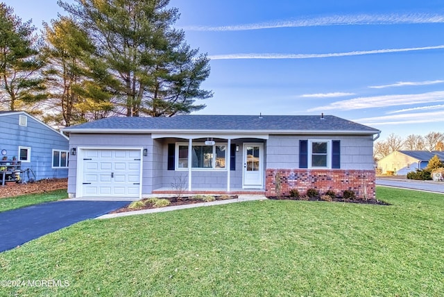 ranch-style home featuring a garage and a front lawn