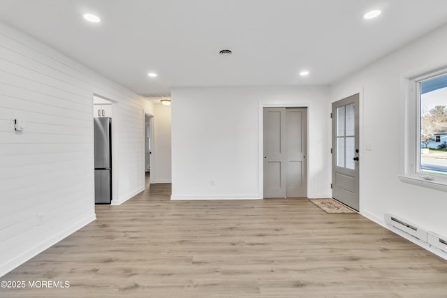 interior space with a baseboard radiator and light hardwood / wood-style floors