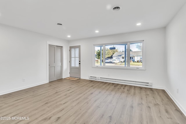 unfurnished room featuring light hardwood / wood-style flooring and a baseboard radiator