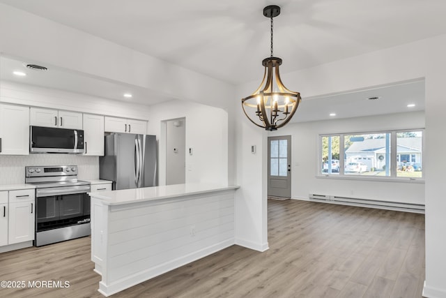 kitchen featuring light hardwood / wood-style flooring, appliances with stainless steel finishes, white cabinetry, a baseboard heating unit, and hanging light fixtures