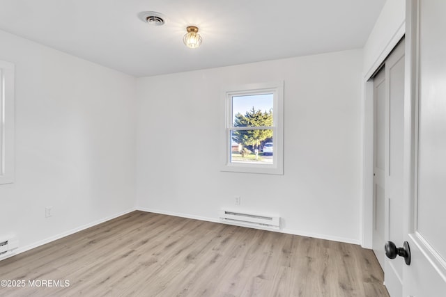 unfurnished bedroom with a baseboard radiator, light wood-type flooring, and a closet