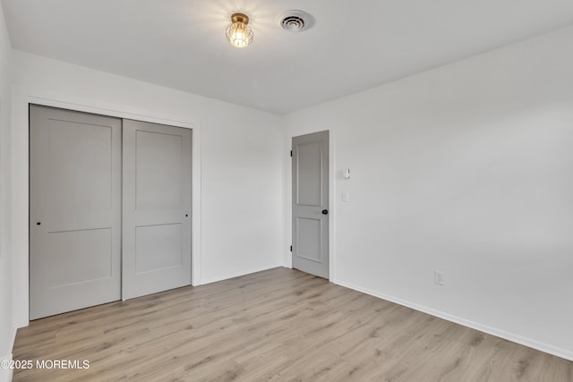 unfurnished bedroom with light hardwood / wood-style floors and a closet