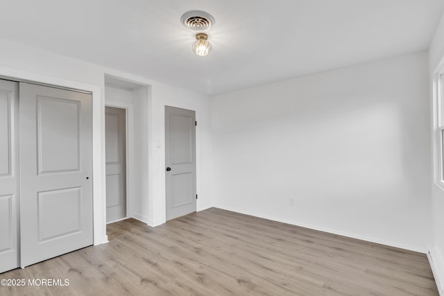 unfurnished bedroom with a closet and light hardwood / wood-style flooring