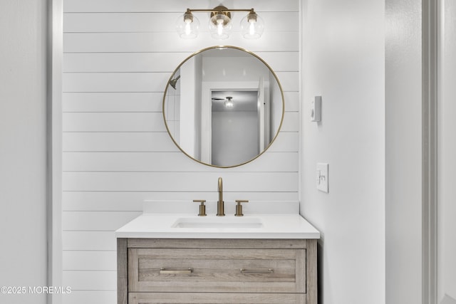 bathroom featuring vanity and wooden walls