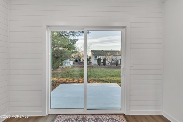 entryway featuring plenty of natural light, wood-type flooring, and wood walls